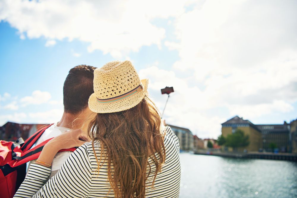 Rear view of couple taking a picture with a selfie stick