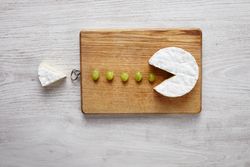 Brie cheese cut like pac man eating grapes
