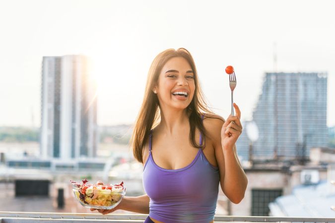 Woman holding a bowl of salad outdoor