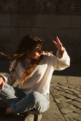 Cheerful female sitting on pavement