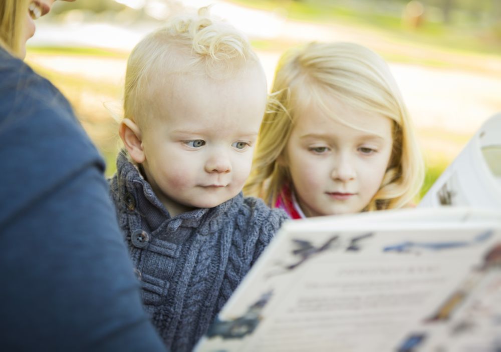 Mother Reading a Book to Her Two Adorable Blonde Children.