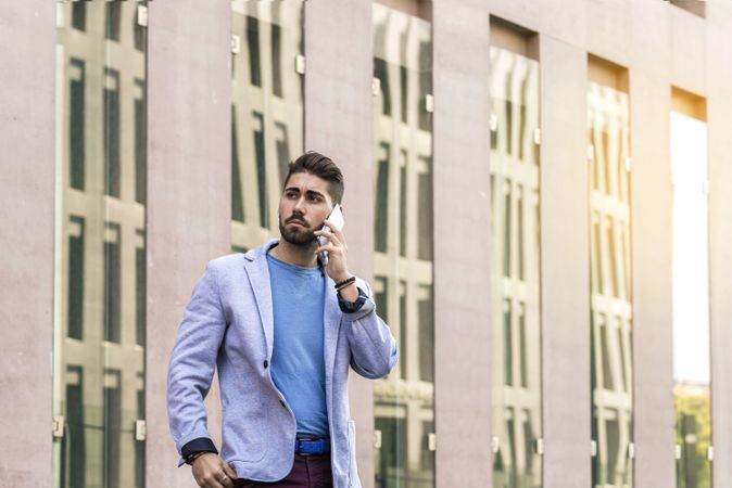 Businessman talking on his phone outdoors on sunny day