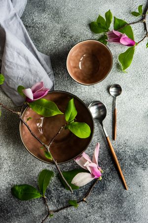 Top view of two bowls with magnolia flowers on grey counter