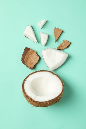 Flat lay with coconut on mint background, top view