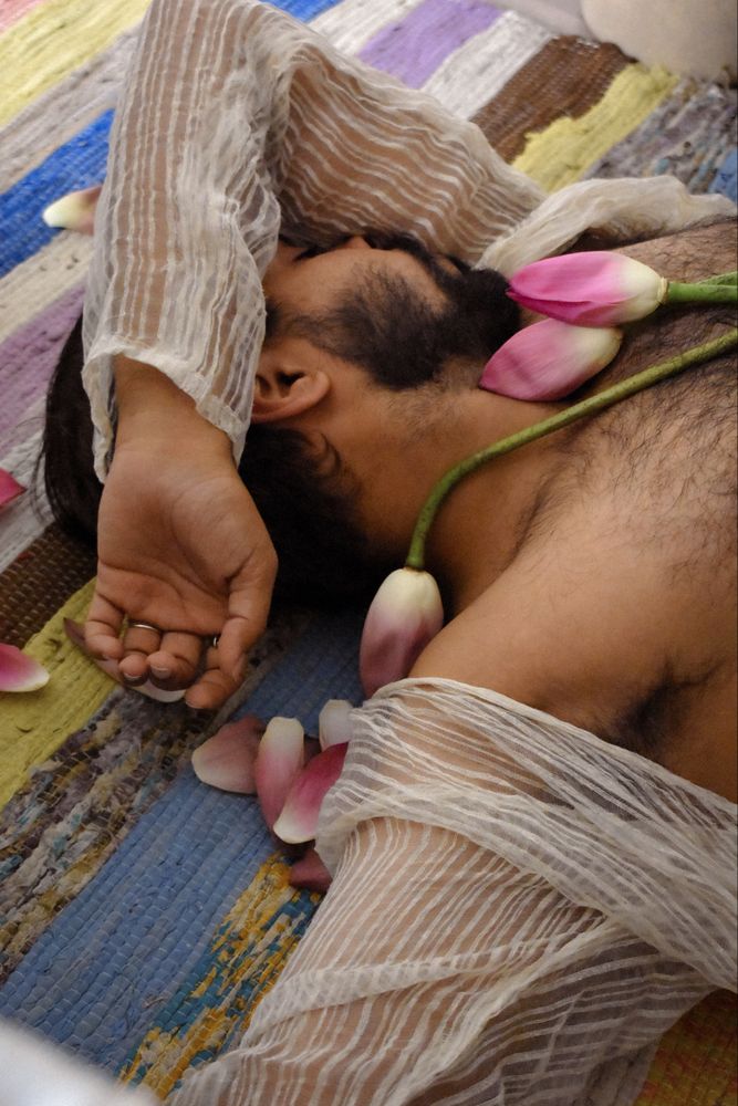 Man in light shirt laying on textile with tulip flowers
