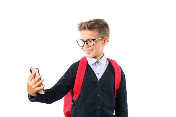 Boy makes selfie on phone isolated on blank background