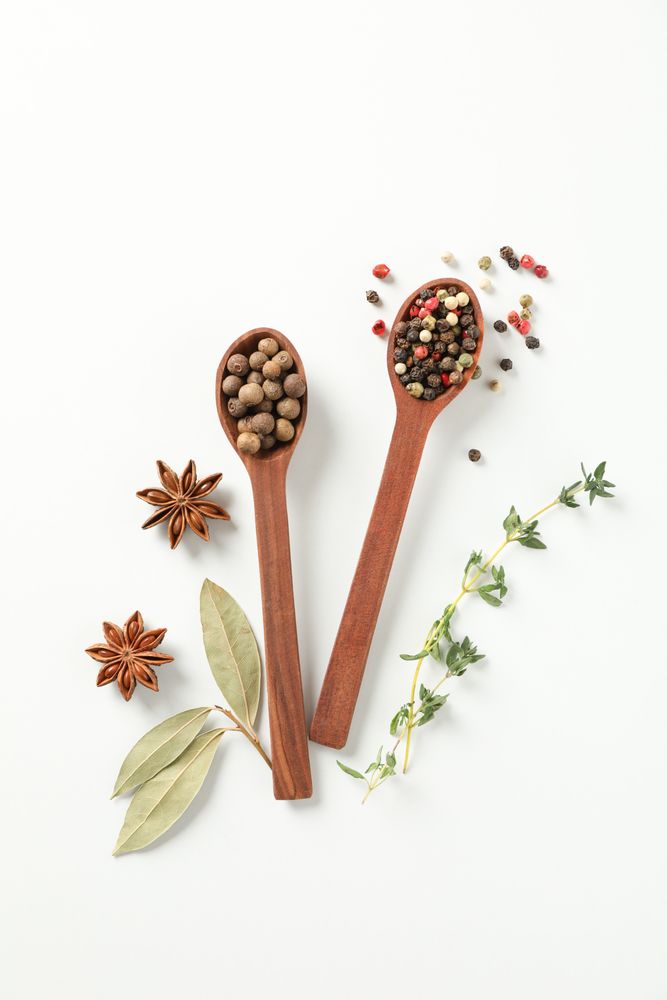 Top view of two wooden spoons full of pepper corns