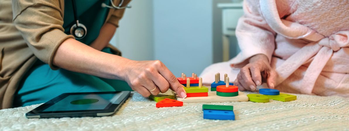 Female doctor showing geometric shapes to mature patient