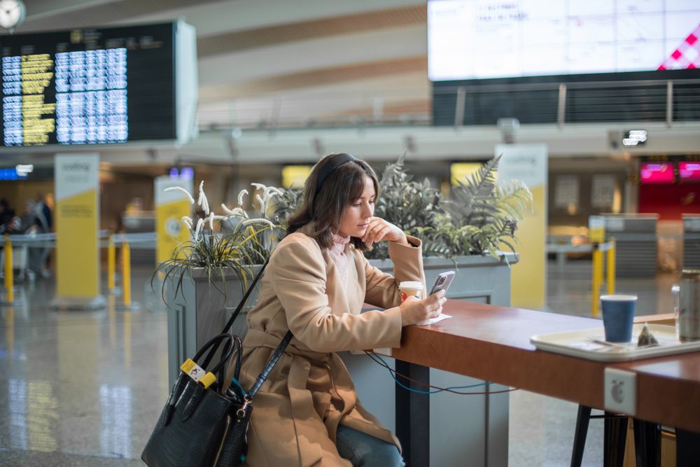 Woman sitting and using smartphone at airport