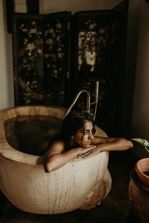 Melancholic Woman sitting and washing in bath
