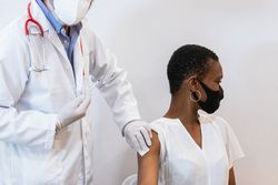 Doctor making injection for Black woman patient