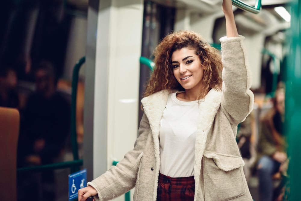 Smiling Arab woman in subway carriage, copy space