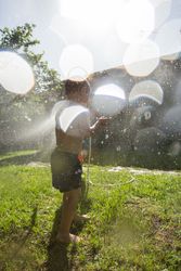 Little kids in swimwear having fun with splashing water