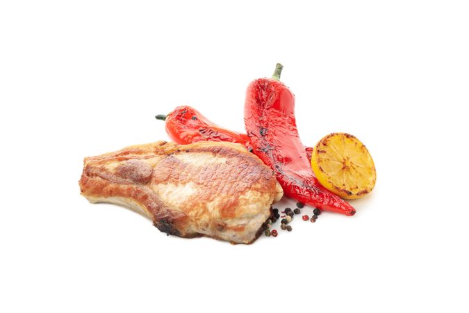 Fried pork steaks and vegetables isolated on light background. Grilled food