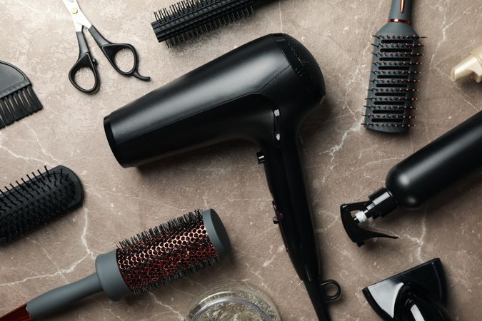 Composition with hairdresser accessories on gray background, top view
