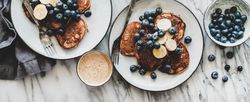 Breakfast banana pancakes with blueberry, honey and coffee, top view, horizontal composition