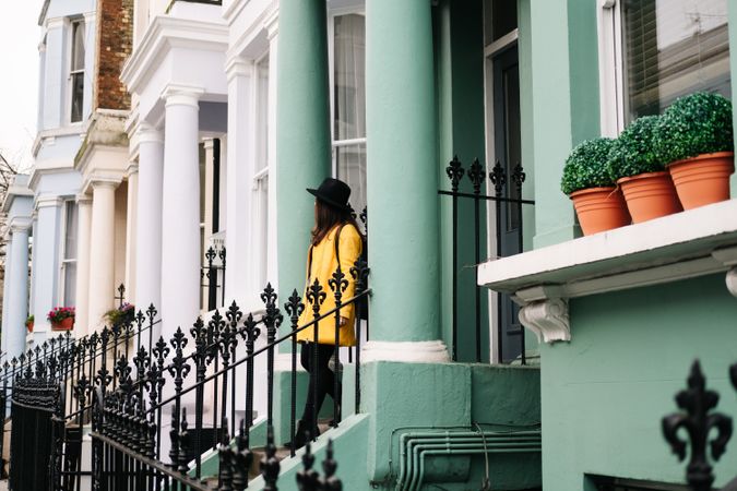 Cheerful woman standing in stairs in typical london buildings