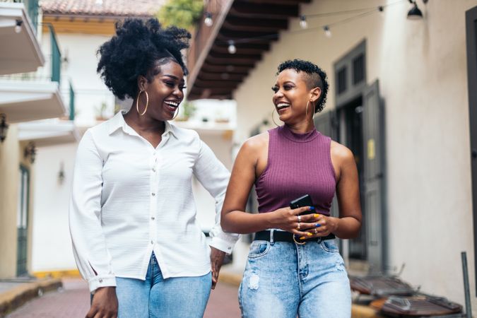 Black women talking and laughing walking in the city