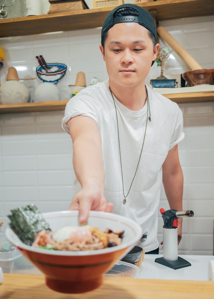 Asian man serving food bowl