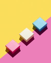 Present boxes over yellow and pink background