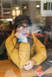 Stylish woman with magazine sitting in cafe