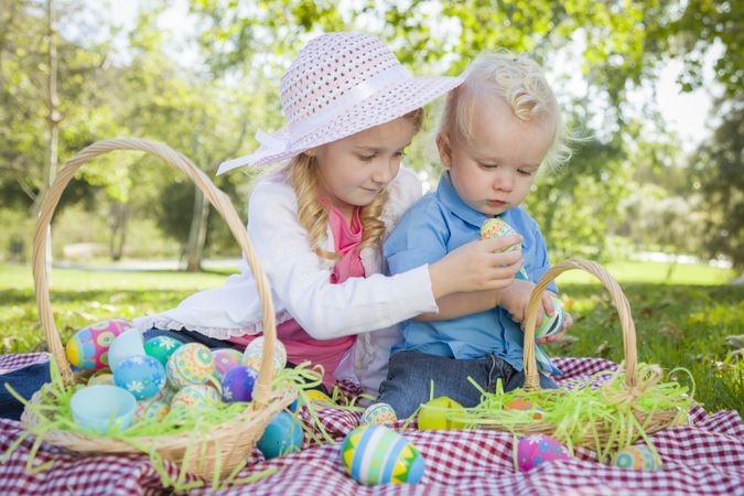 Cute Young Brother and Sister Enjoying Their Easter Eggs Outside