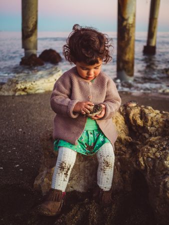 small girl playing with seashell