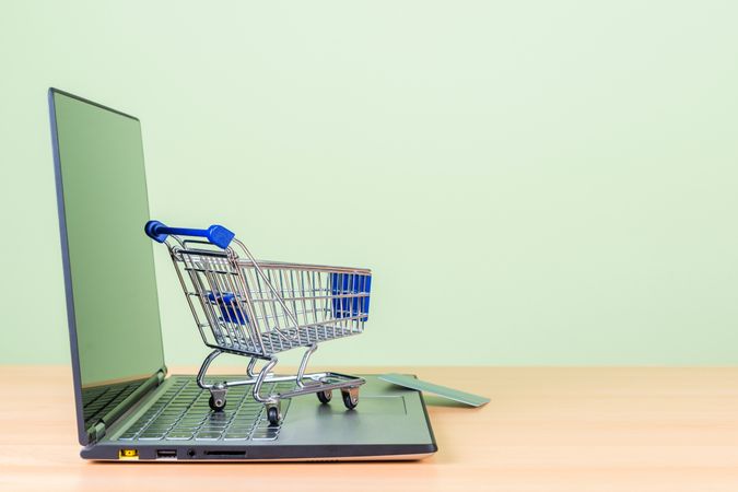 Online Shopping Concept with Miniature Shopping Cart on Laptop Keyboard