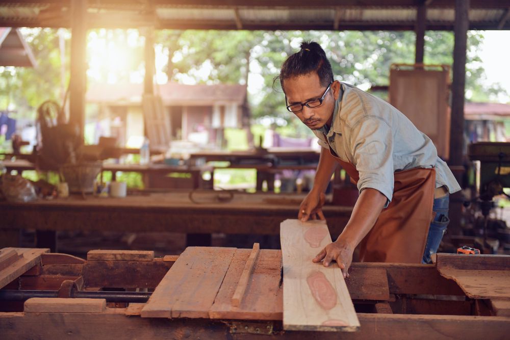 Carpenter putting a wooden plank on a table