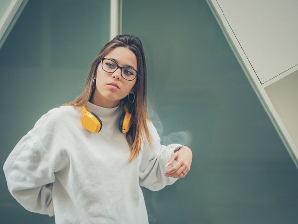 Trendy young woman with headphones and smartphone