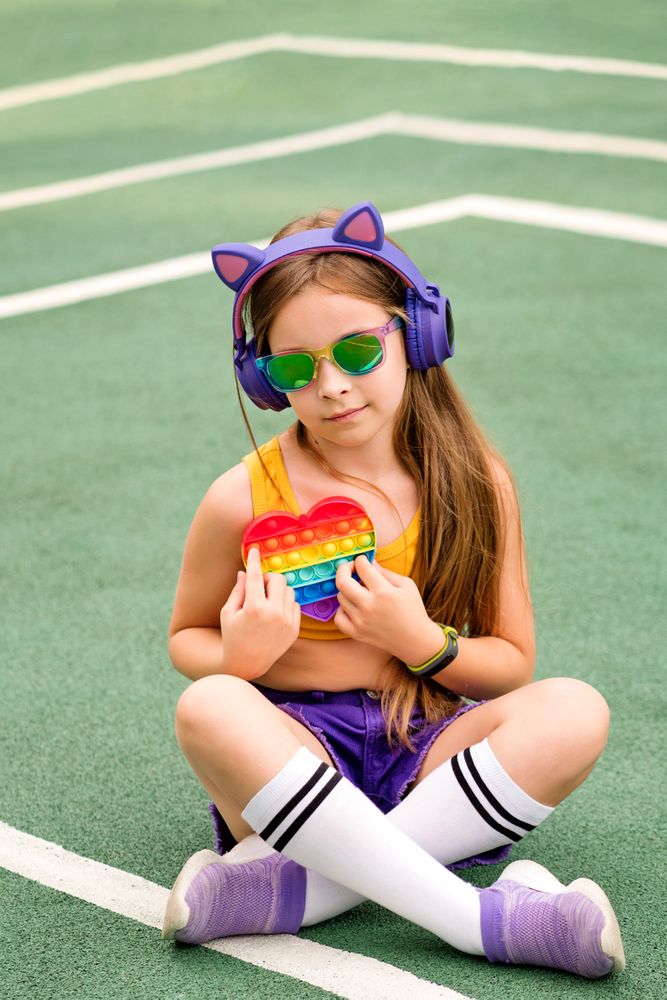 School girl in sunglasses with toy
