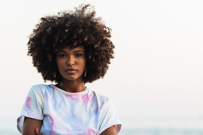 Unemotional Black woman standing on seashore