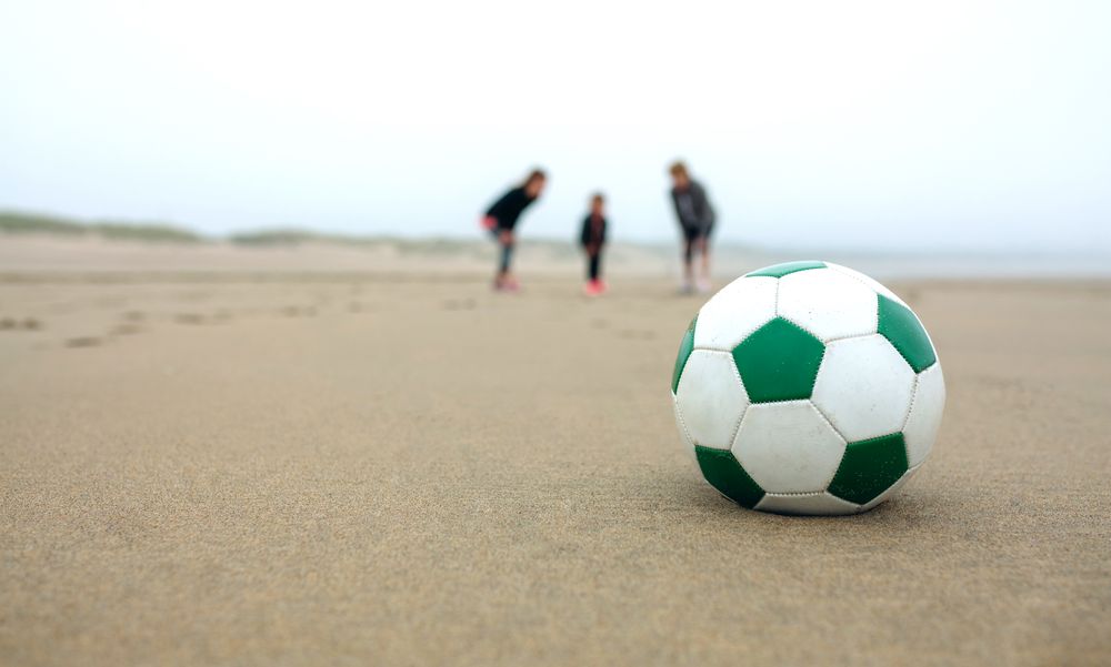 Close up of soccer ball with three people