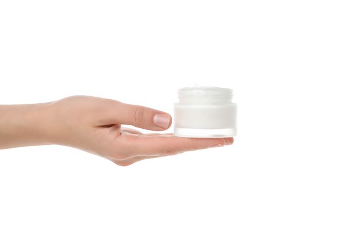 cream in hands, isolated on light background.