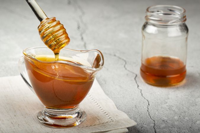 Honey in glass bowl on the table.