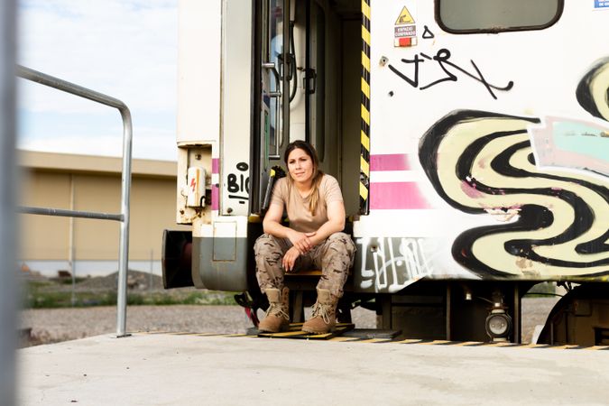 Military woman sitting near van