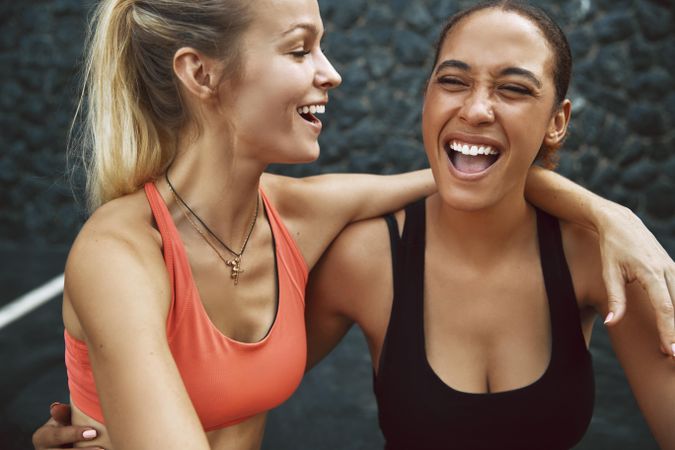 Two women in sports bras laughing together