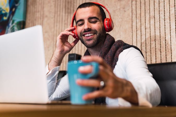 Happy freelancer enjoying music in cafe