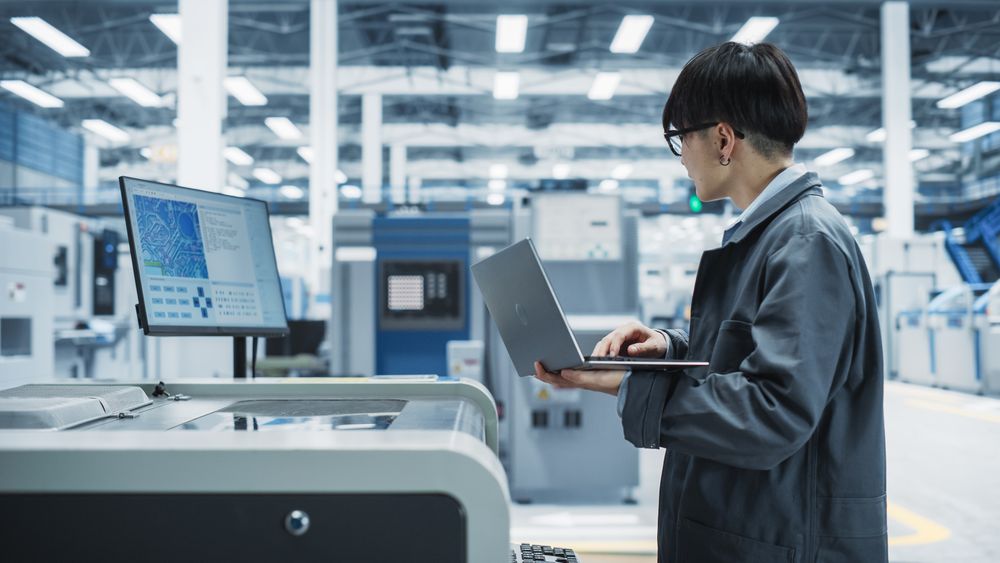 Side view of Asian man working with laptop