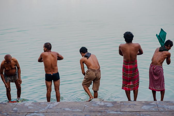 Back view of Indian men washing in holy river in India