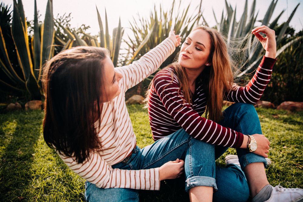 Two young women having fun outside wearing similar outfits