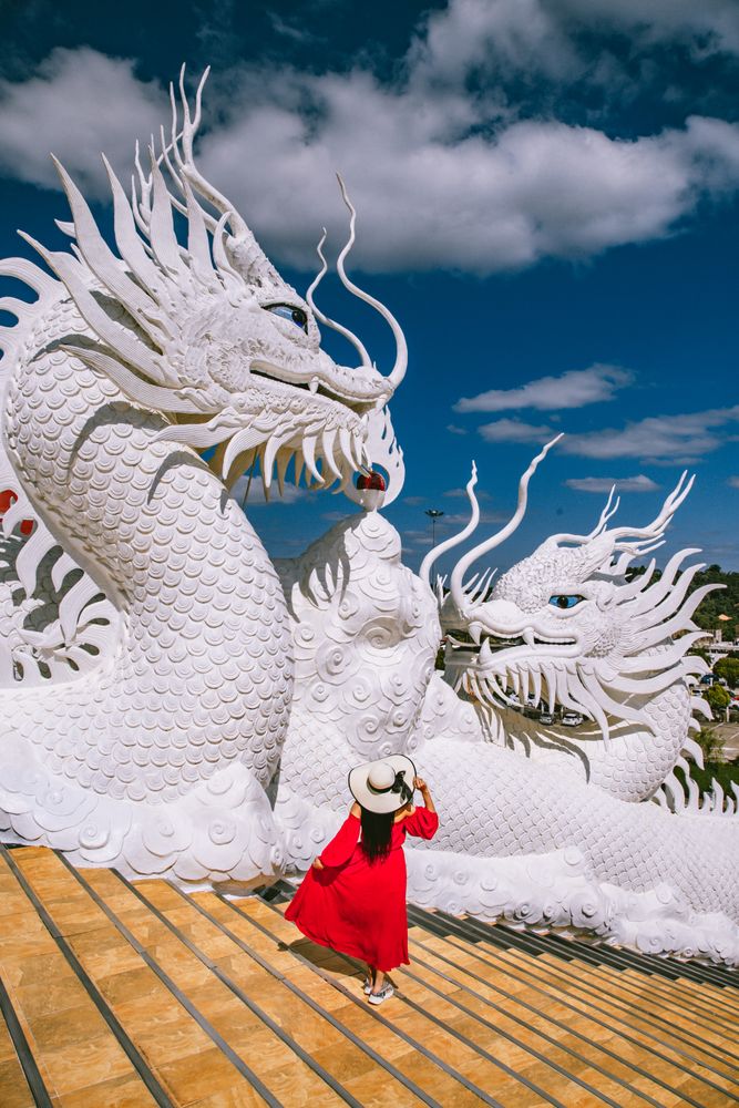 Woman in red dress beside Wat Huay Pla Kang temple in Chiang Rai, Chiang Mai province, Thailand