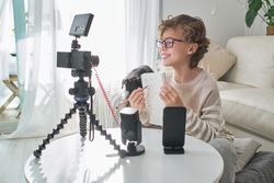Smiling boy recording video at home