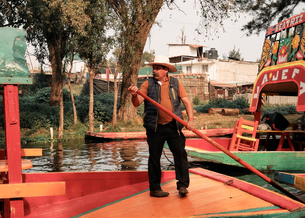 Man steering colorful boat in river