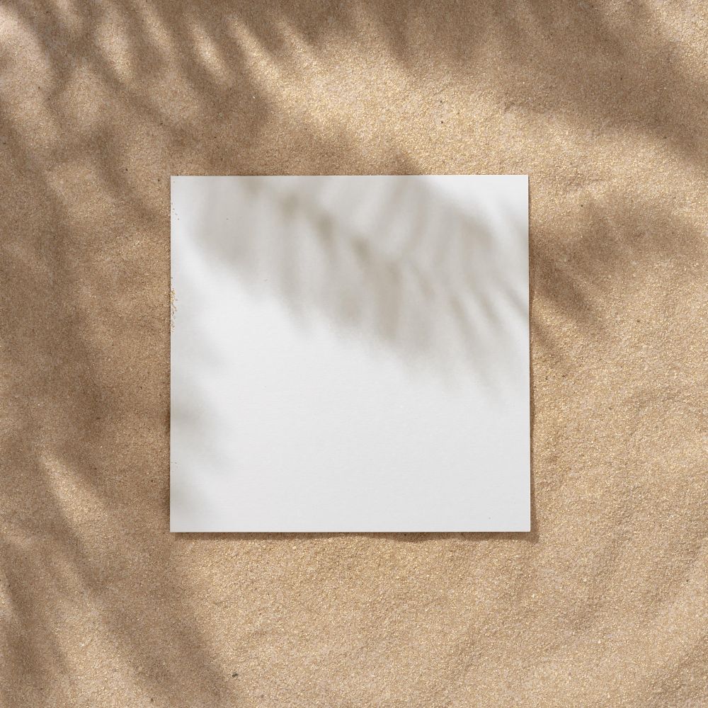 Sand with palm leaf shadows and central square