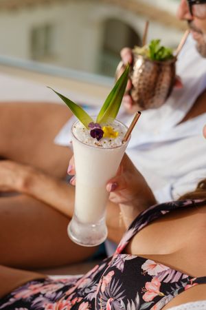 Crop couple enjoying delicious cocktails together