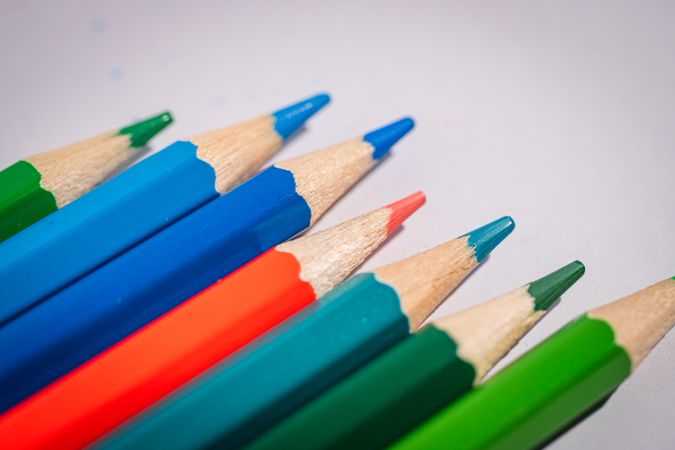 A row of pencils with different colors, including blue, green, and red