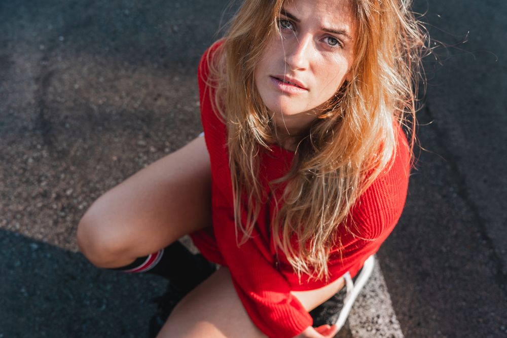 Charming woman in sweater on street between puddles