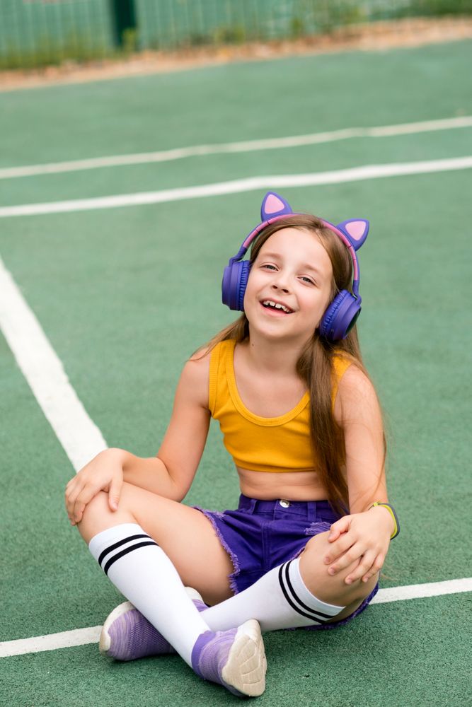 Female child sitting on sports ground