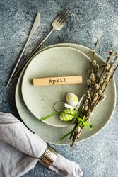 Easter concept with pussy willow and green decorative eggs on ceramic plates